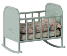 Load image into Gallery viewer, Light blue baby crib with floral bedding on a white background