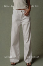 Load image into Gallery viewer, White wide-leg jeans worn by a person on a green background