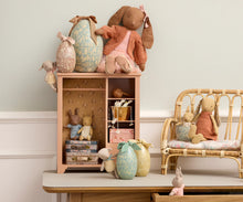 Load image into Gallery viewer, Collection of plush toys on a wooden shelf and chair against a light-colored wall.