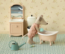 Load image into Gallery viewer, Toy mouse in a bathtub with bathroom furniture and accessories on a patterned floor.