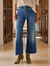 Load image into Gallery viewer, Person wearing blue jeans and green boots in a home setting