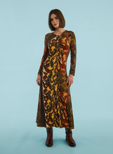 Load image into Gallery viewer, Woman wearing a long, patterned dress against a light blue background